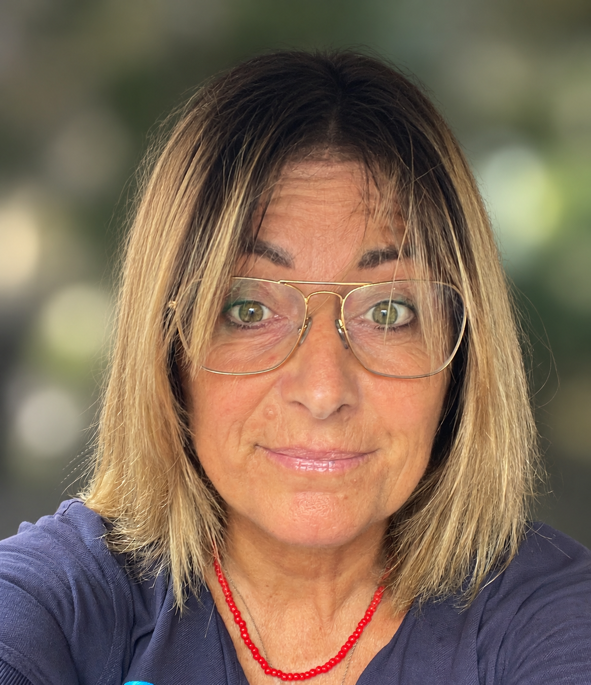 Ritratto di Gina Palma con occhiali chiari e sfondo sfocato